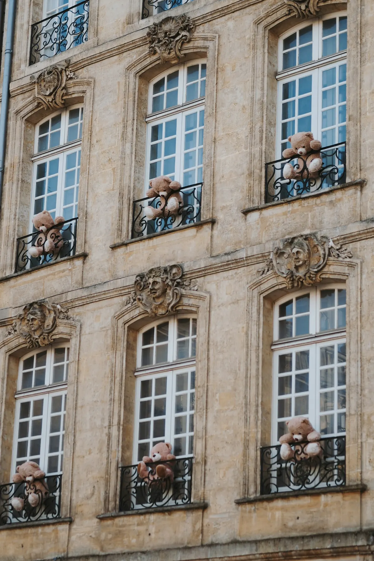 Façade en pierre blonde avec balcons en fer forgé à Bordeaux