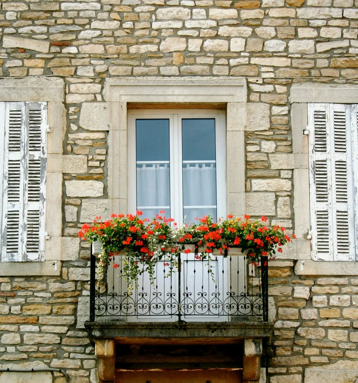 Volets en bois repeints sur une façade en pierre
